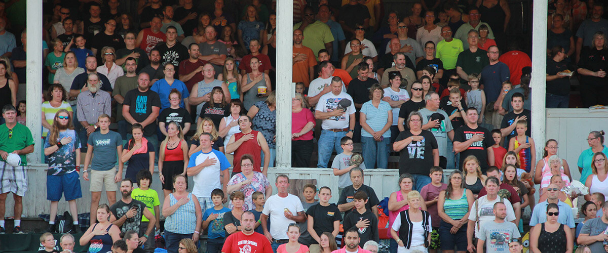 Fair fans stand for the national anthem